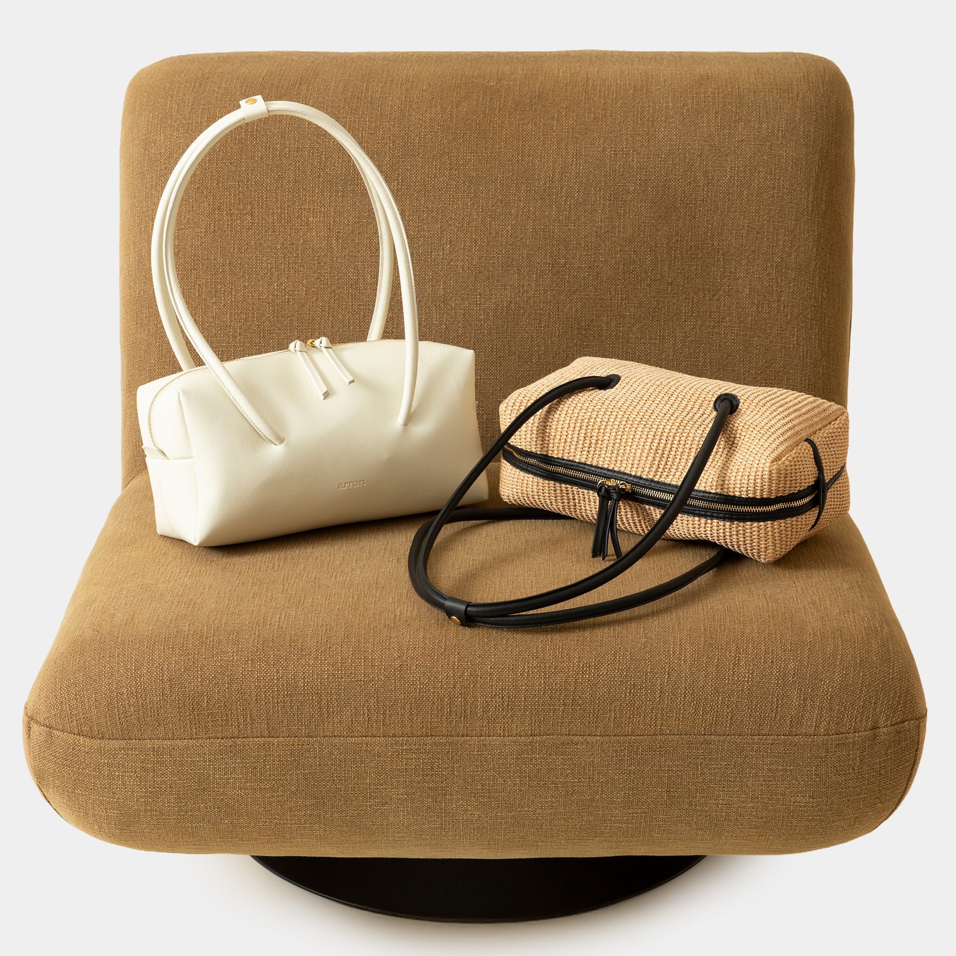 borsa Carol in rafia ecru e pelle nera del marchio Arron scultorea grafica e di design con manico rigido stile minimal giapponese dettagli ambientato lifestyle
