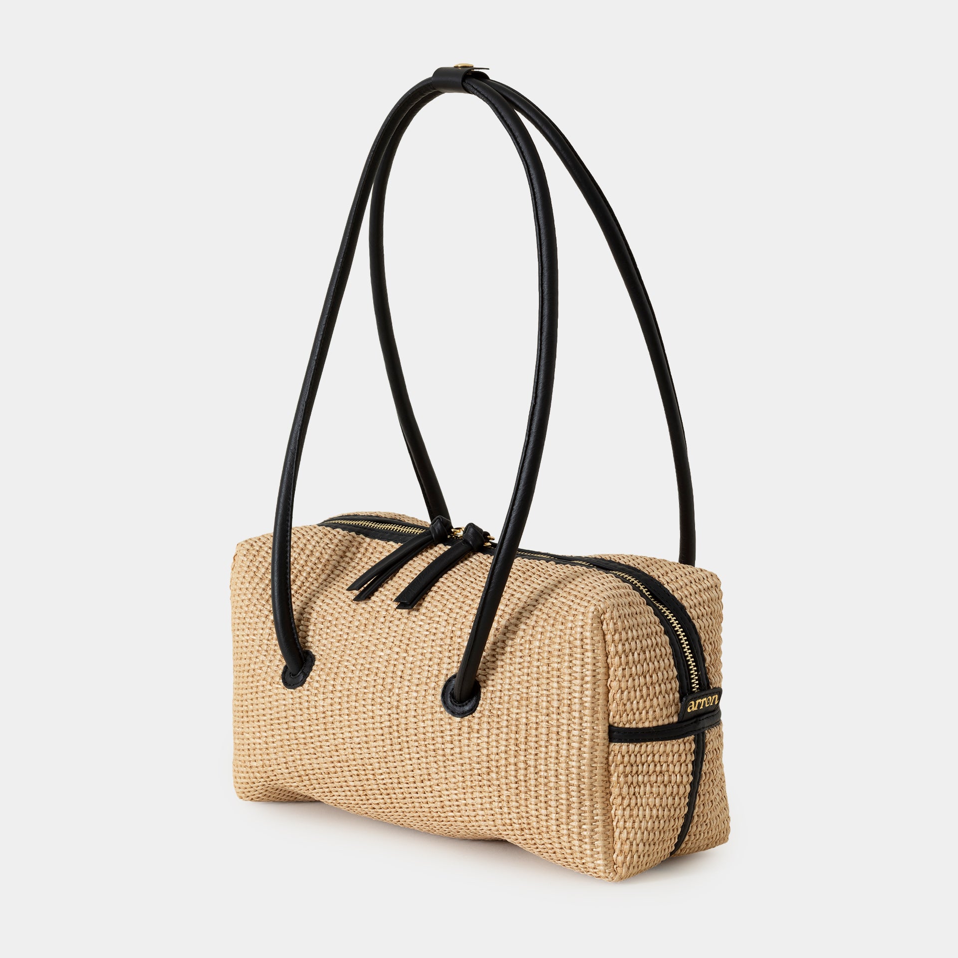 borsa Carol in rafia ecru e pelle nera del marchio Arron scultorea grafica e di design con manico rigido stile minimal giapponese vista laterale