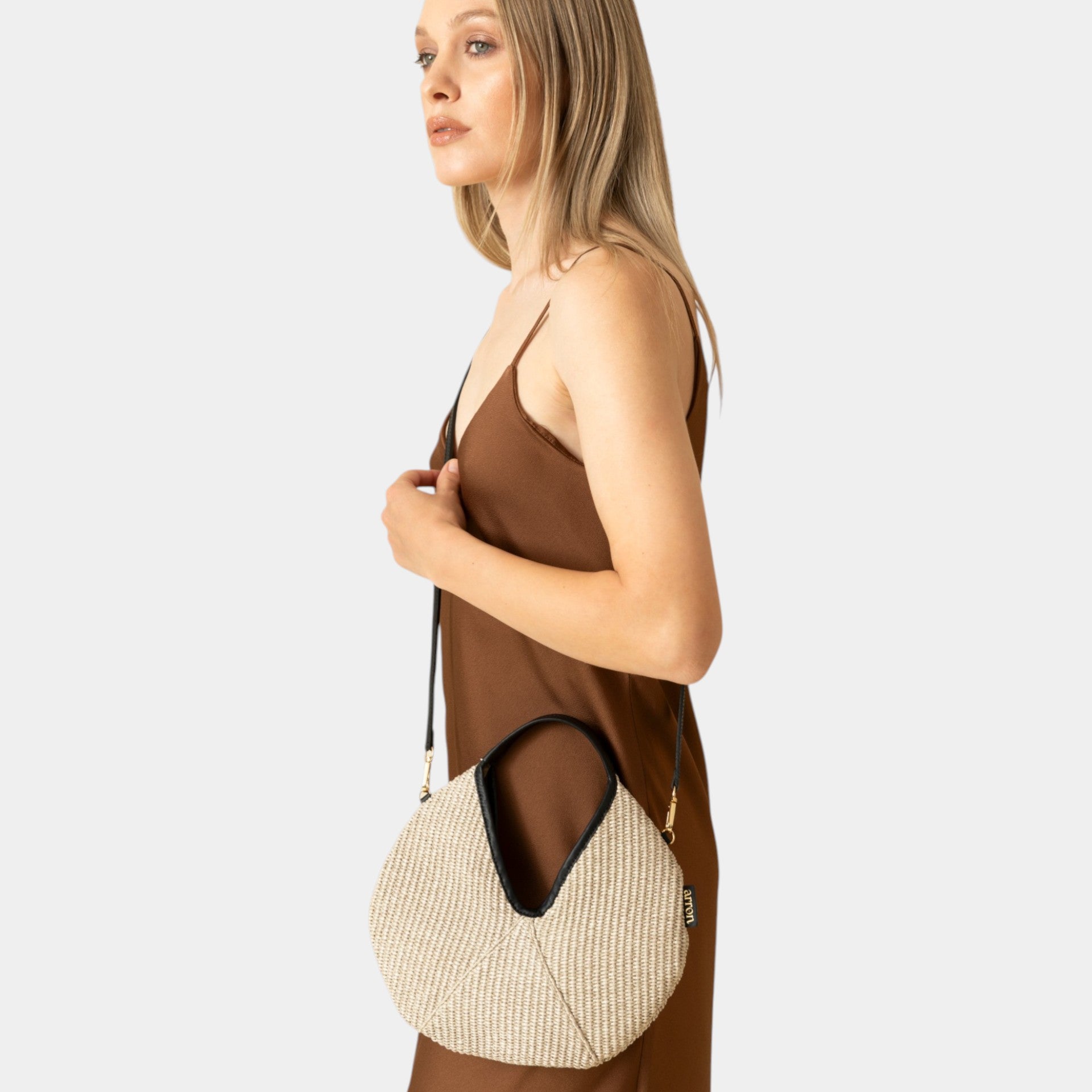 mini borsa Arron in rafia taupe e pelle nera made in Italy indossata a spalla