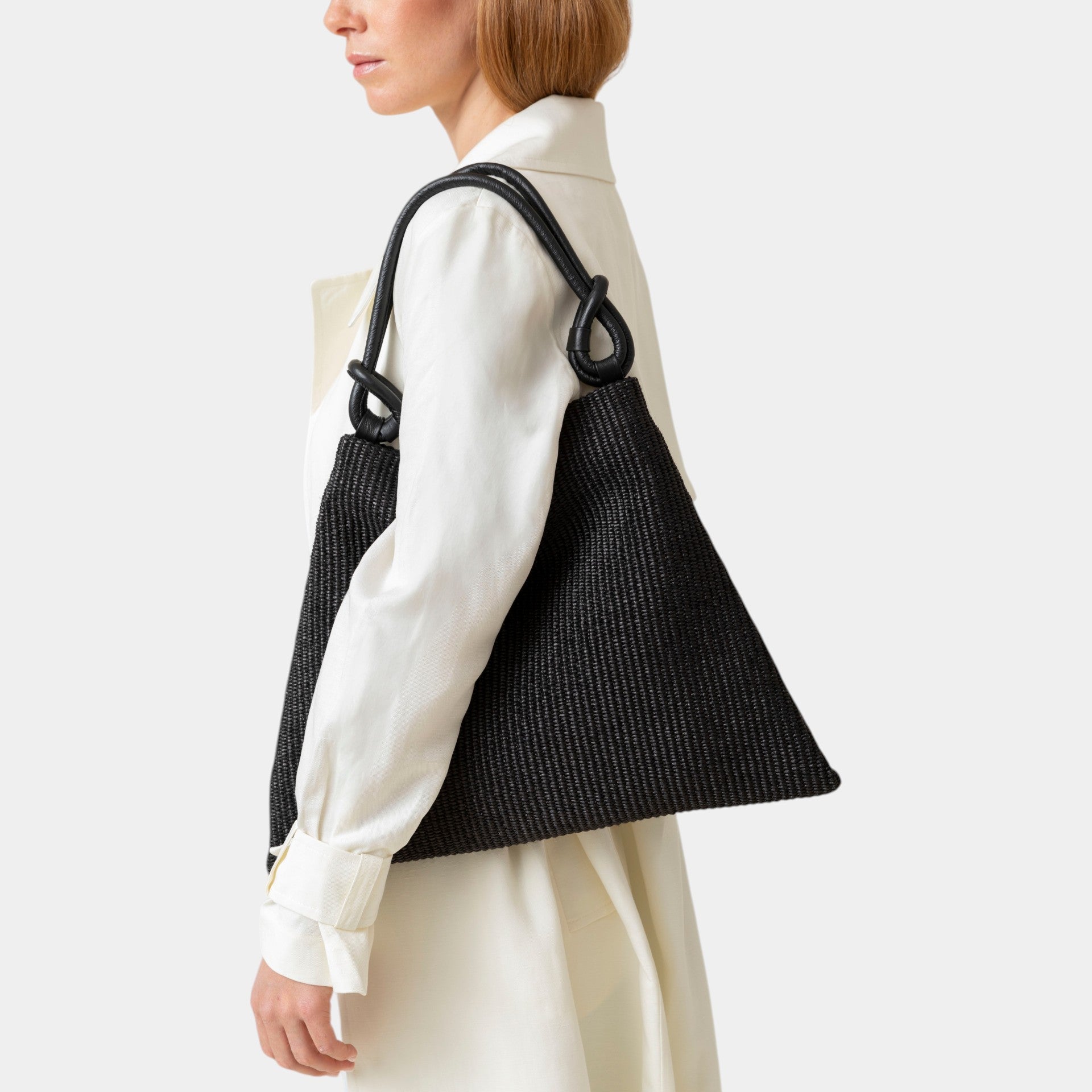 poppy borsa in rafia nera e manico in pelle nera con nodi in taglia L marchio Arron indossata a spalla