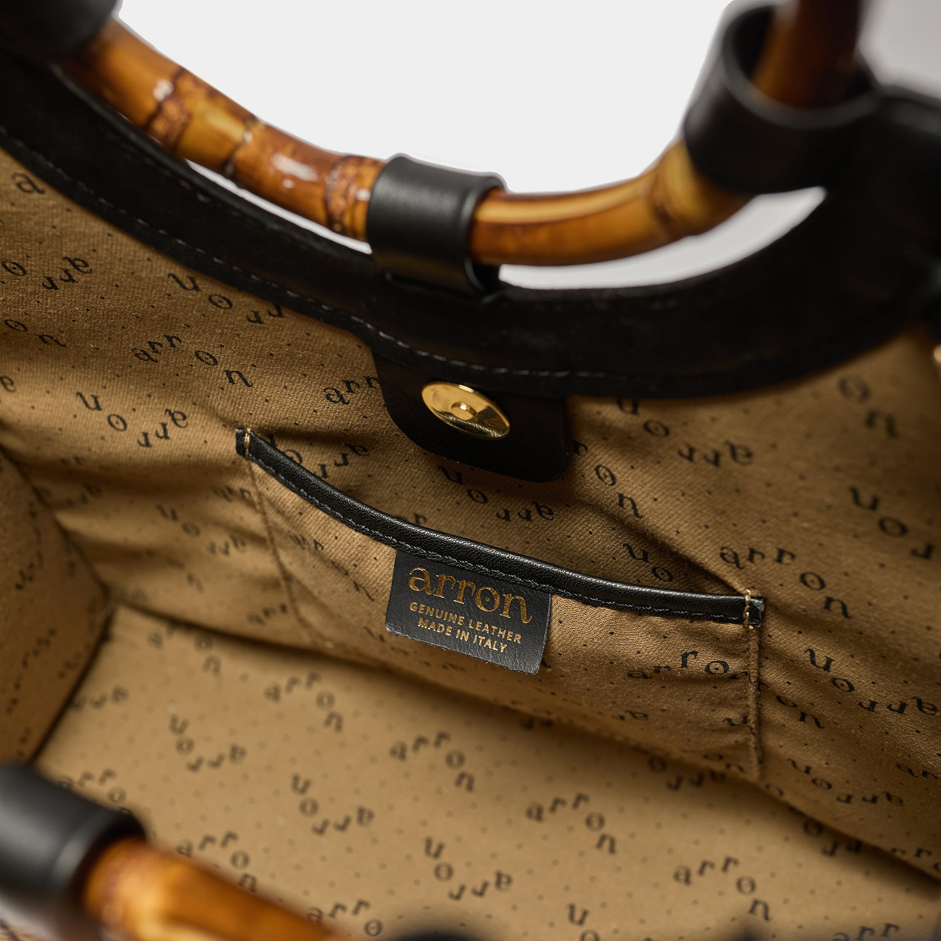 Interno di Bamboo bag in rafia rigata e pelle nera con manico in bamboo Arron e tracolla taglia media
