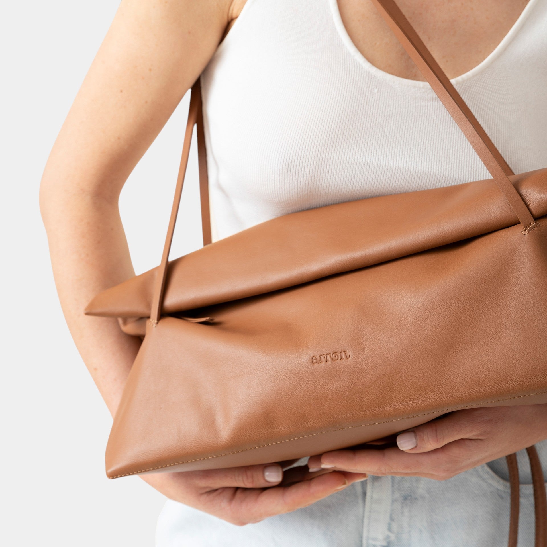 borsa Otta made in Italy del brand Arron  in pelle color cognac, forma allungata east west, trendy, leggera manici fini indossata 
